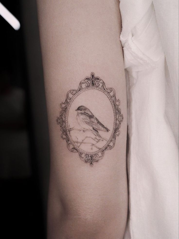 a bird is sitting on the arm of a woman with a frame around it's neck