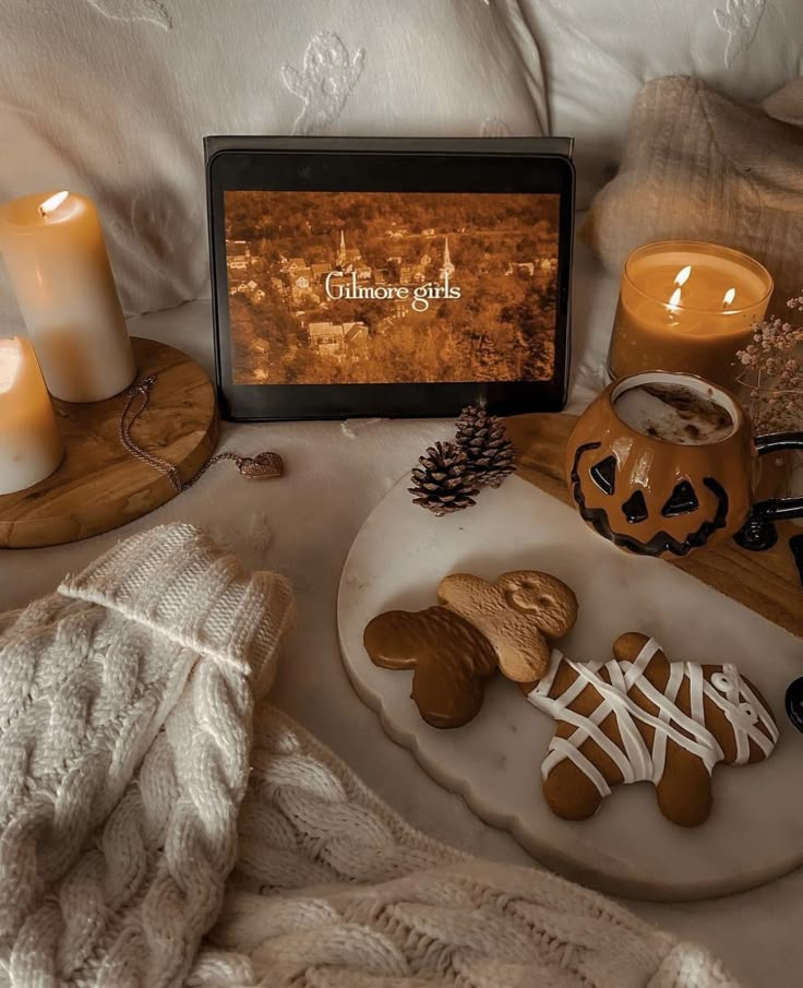 a table topped with cookies and candles on top of a bed