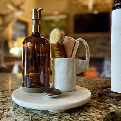 a bathroom counter with a cup, brush and soap dispenser on it