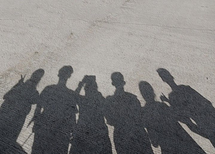 the shadow of several people standing next to each other