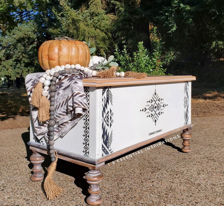 an old trunk is decorated with beads, tassels and a pumpkin on top