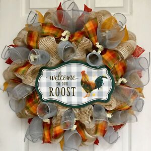 a welcome to our roost mesh wreath hanging on a door