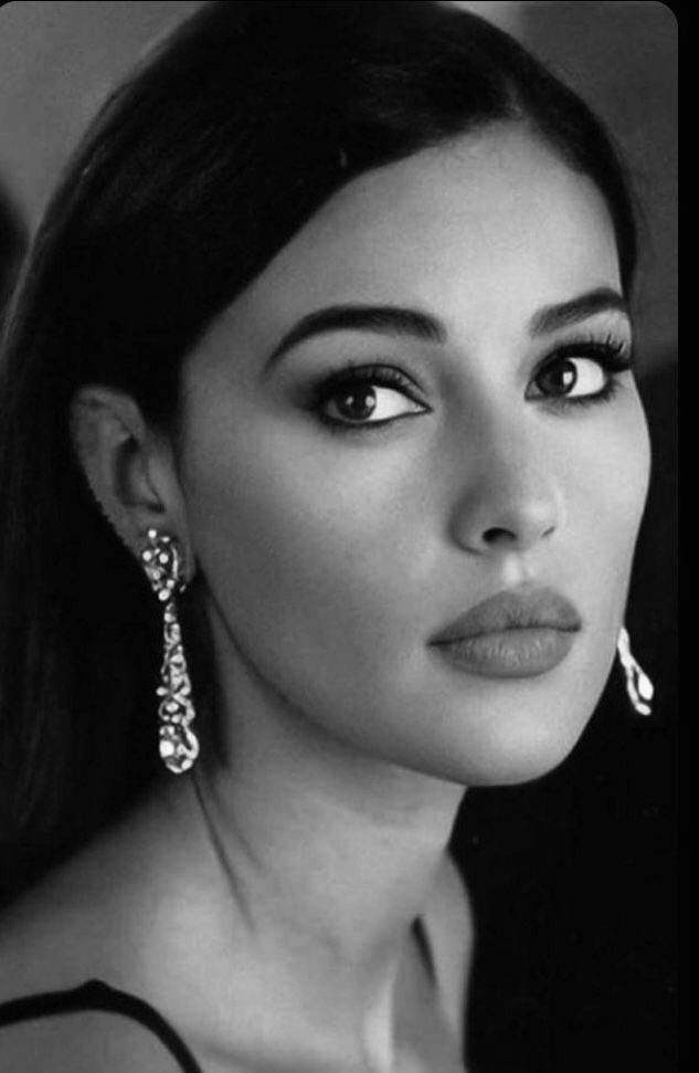 black and white photo of a woman wearing earrings