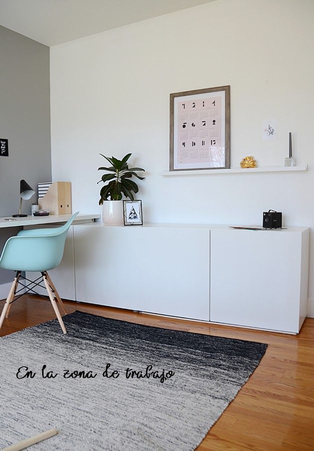 a room with a desk, chair and rug in it