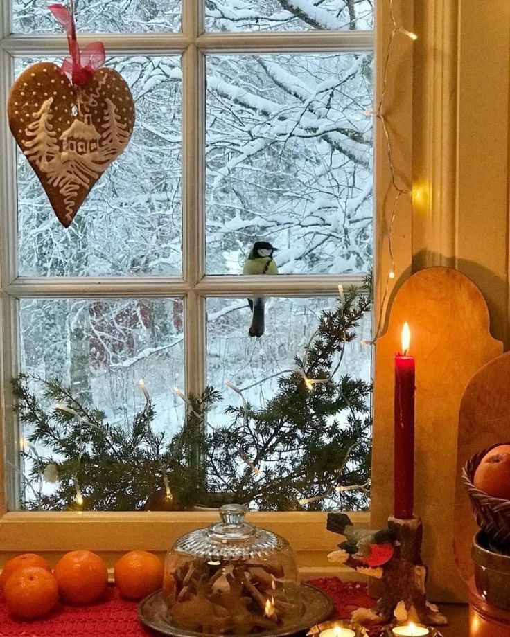 a table topped with cakes and candles next to a window