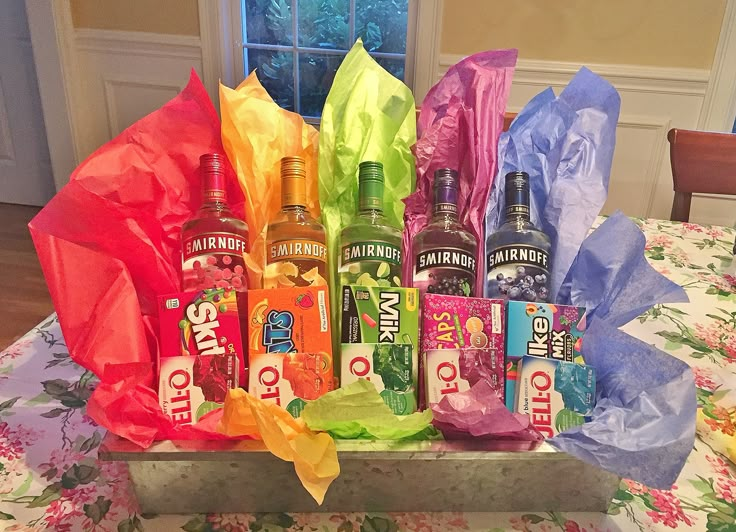 an assortment of liquors and candy wrapped in tissue paper on a dining room table