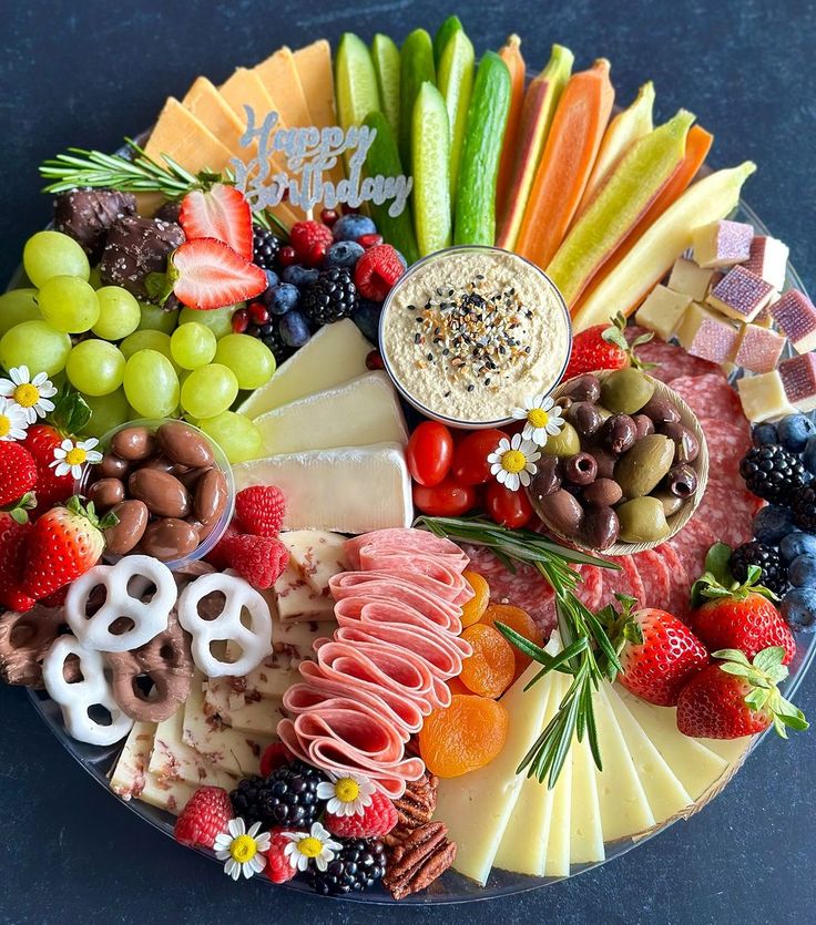 a platter filled with fruit, cheese and crackers