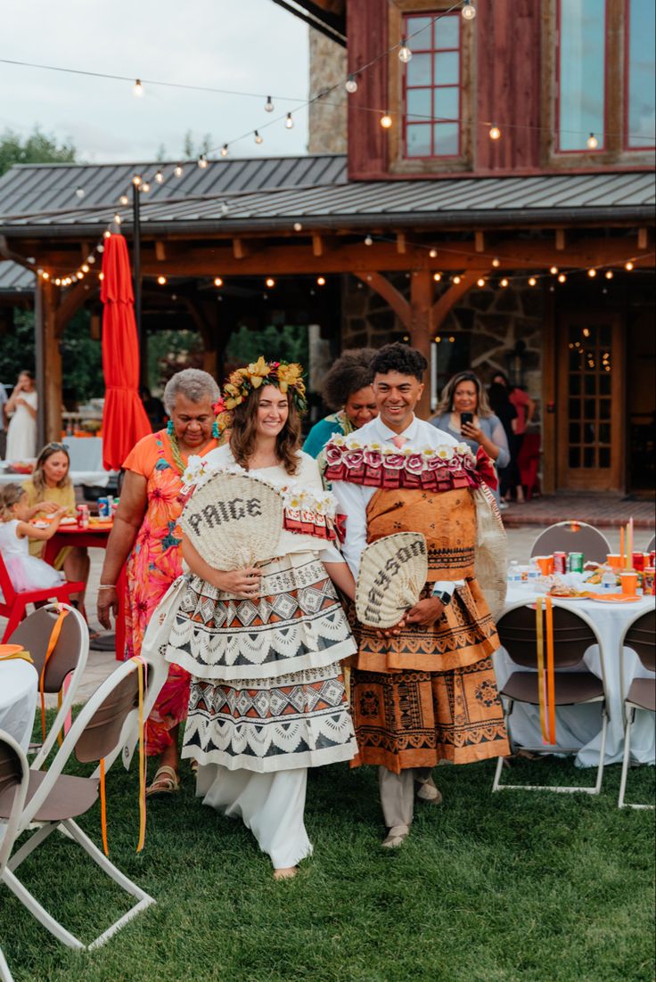 two women and one man are dressed in native clothing