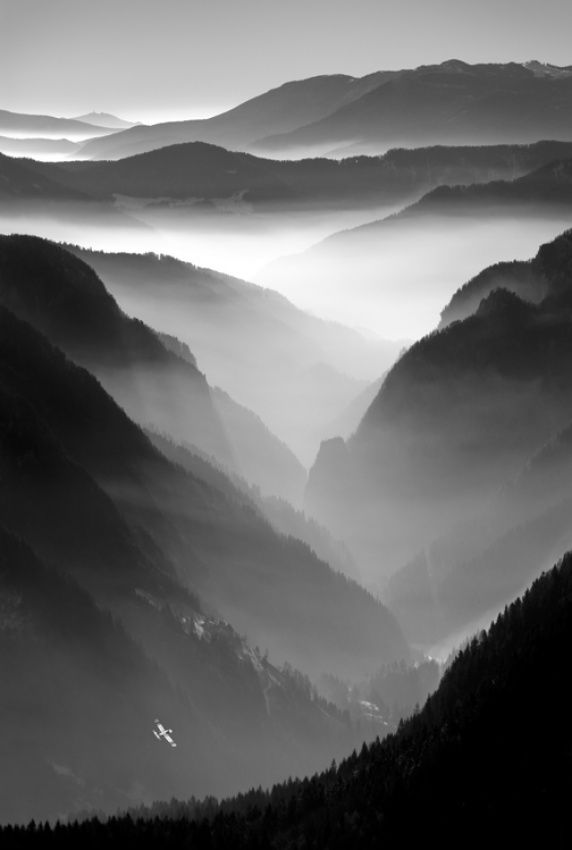 black and white photo of mountains with fog