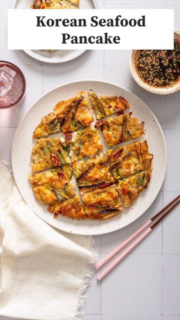 korean seafood pancake on a plate with chopsticks next to it and two drinks