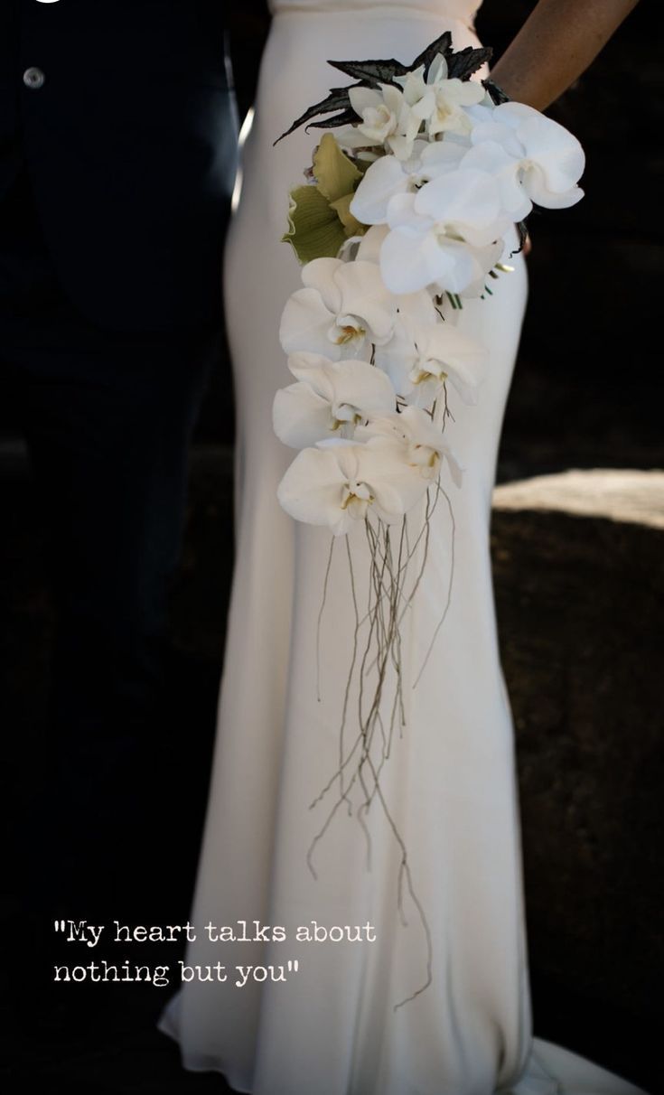 a person in a white dress holding a bouquet of flowers