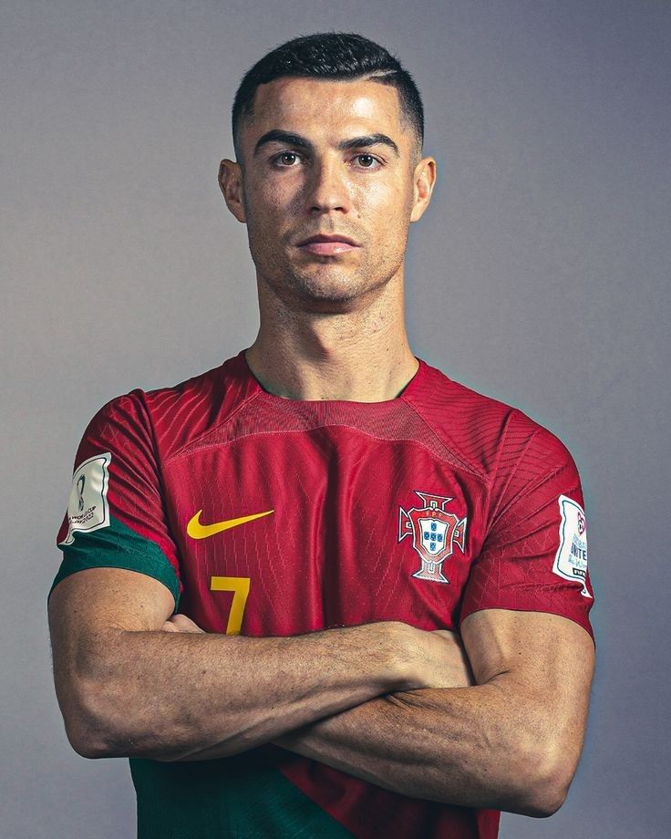 a soccer player is posing for a photo with his arms crossed and looking at the camera