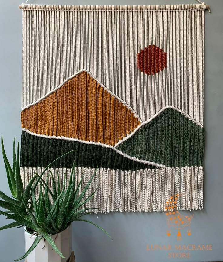 the wall hanging is decorated with mountains and plants