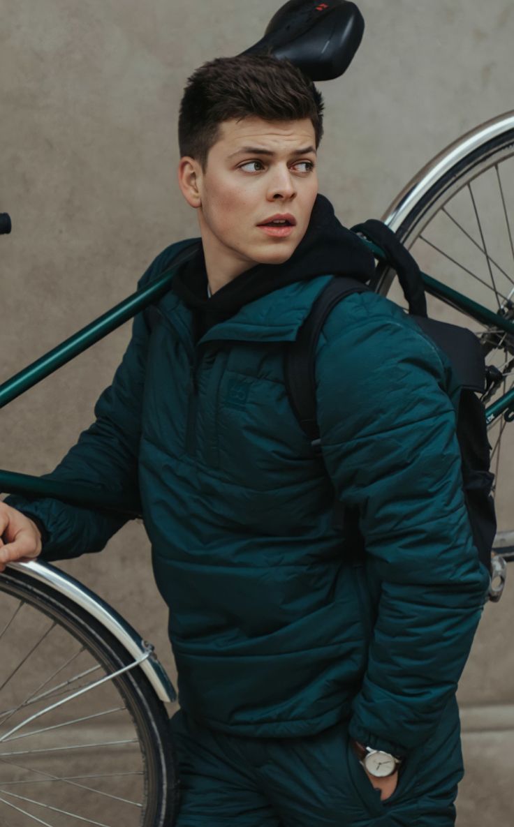 a young man is carrying his bike on the back