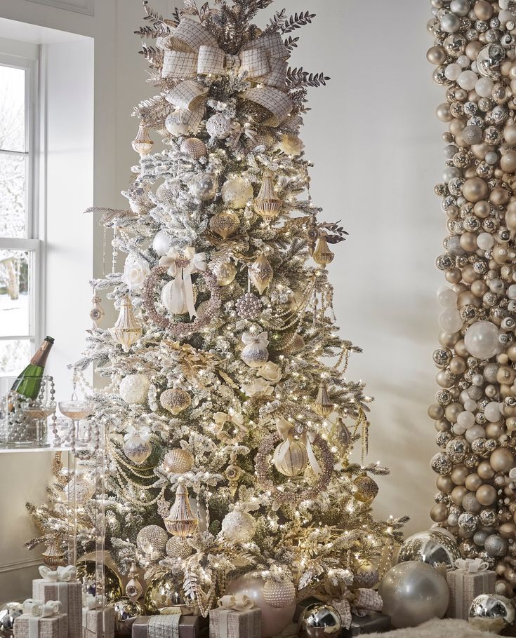 a white christmas tree with silver and gold ornaments