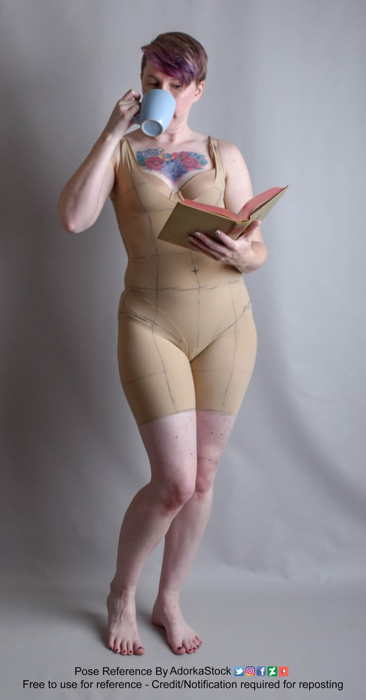 a woman in a bodysuit holding a book and drinking from a cup