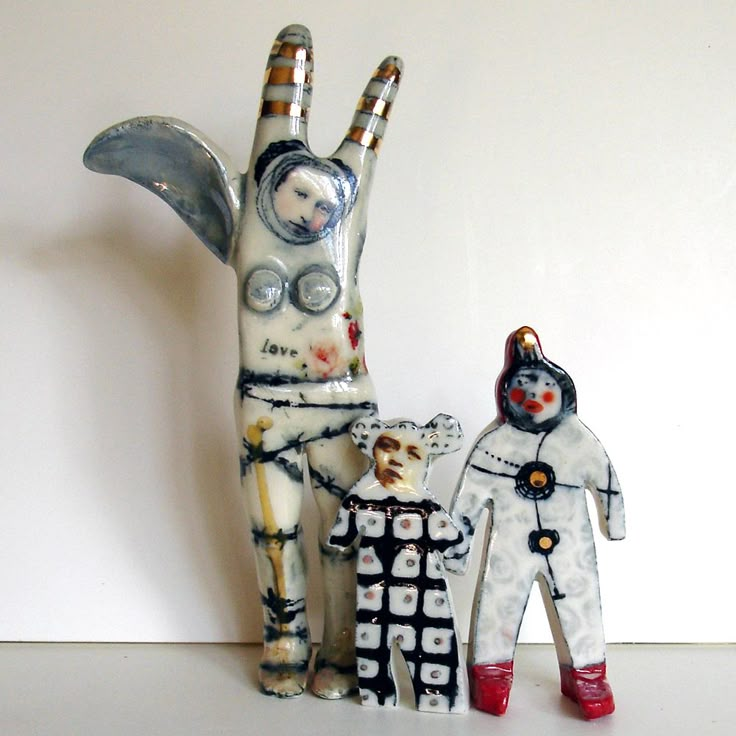 two ceramic figurines are standing next to each other