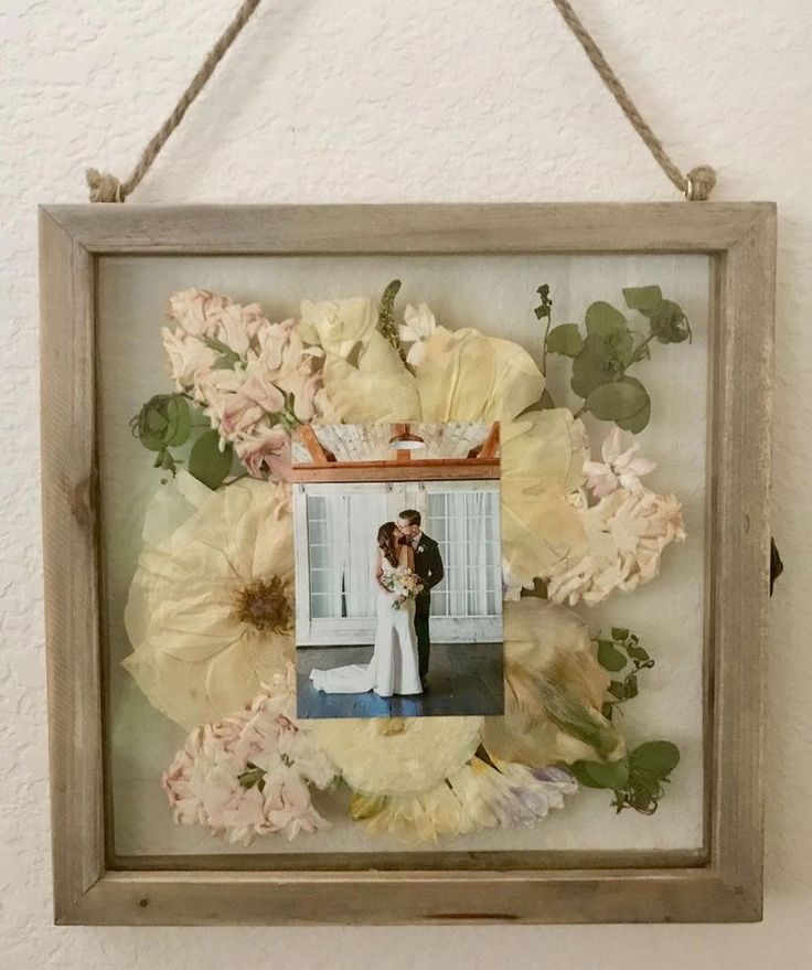 a photo frame with flowers hanging on the wall