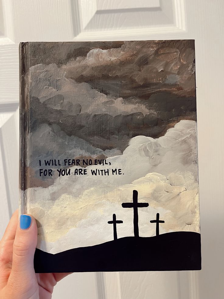 a person holding up a book with a painting on it that says i will fear anything for you are with me