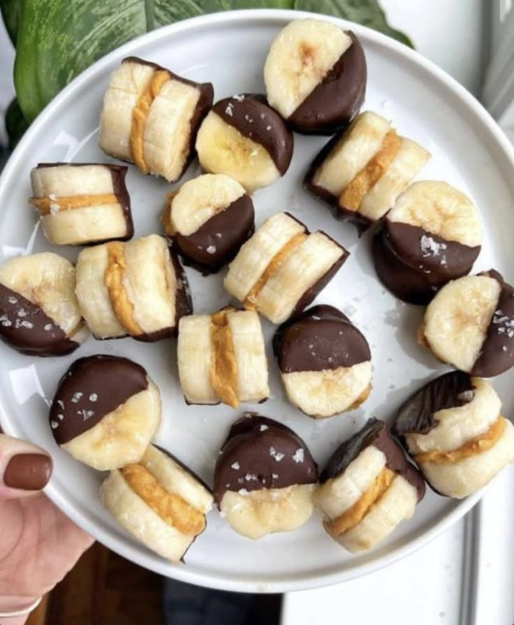 a white plate topped with chocolate covered bananas