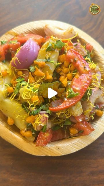 a wooden bowl filled with vegetables on top of a table