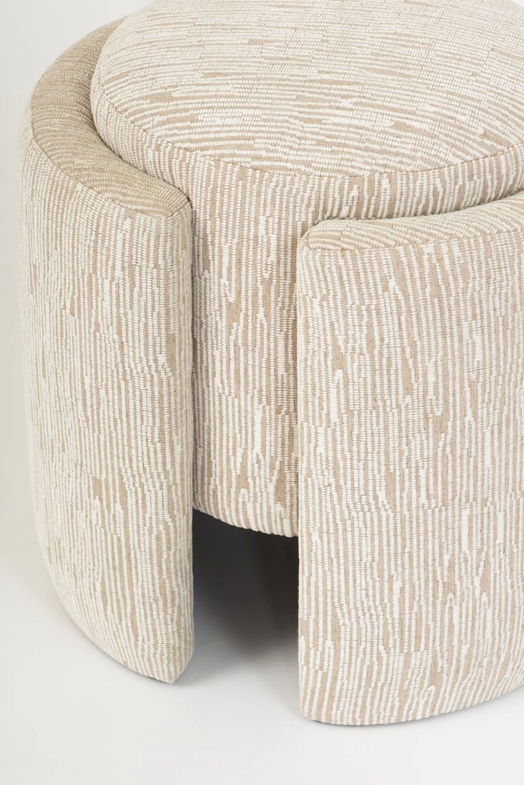 an upholstered stool with two legs and a circular seat on the bottom is made out of fabric