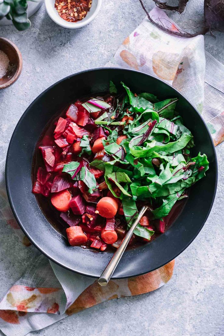 a bowl filled with greens and sliced beets