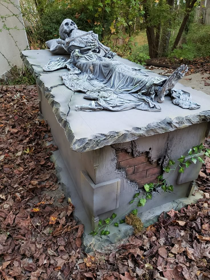 a statue is laying on top of a pile of leaves