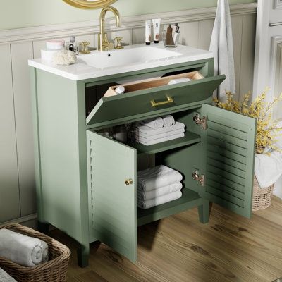 a bathroom with a sink and green cabinet