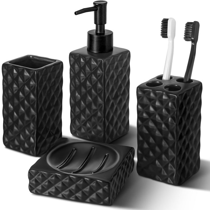 black bathroom accessories set with toothbrush holder and soap dispenser on white background