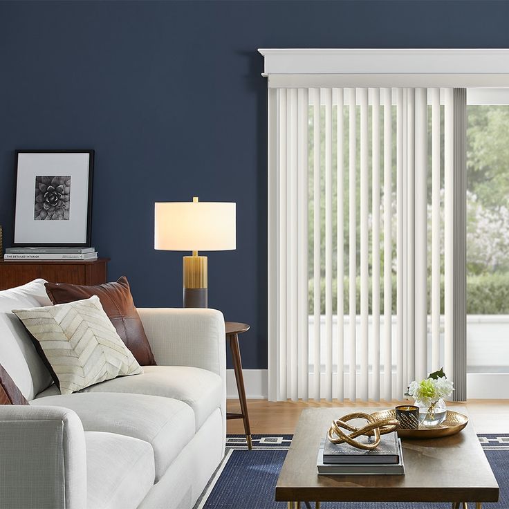 a living room with blue walls and white blinds