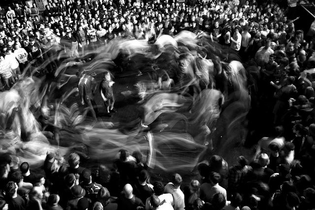 black and white photograph of people in front of a crowd at a sporting event with horses