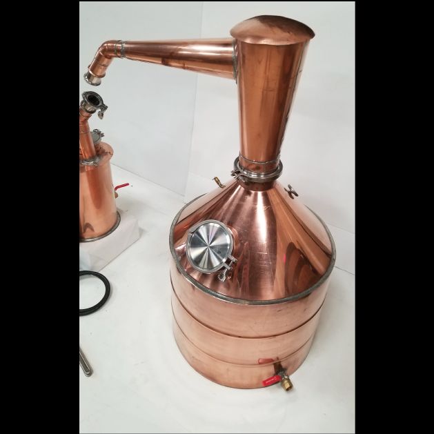 a copper colored coffee pot sitting on top of a white counter next to a machine