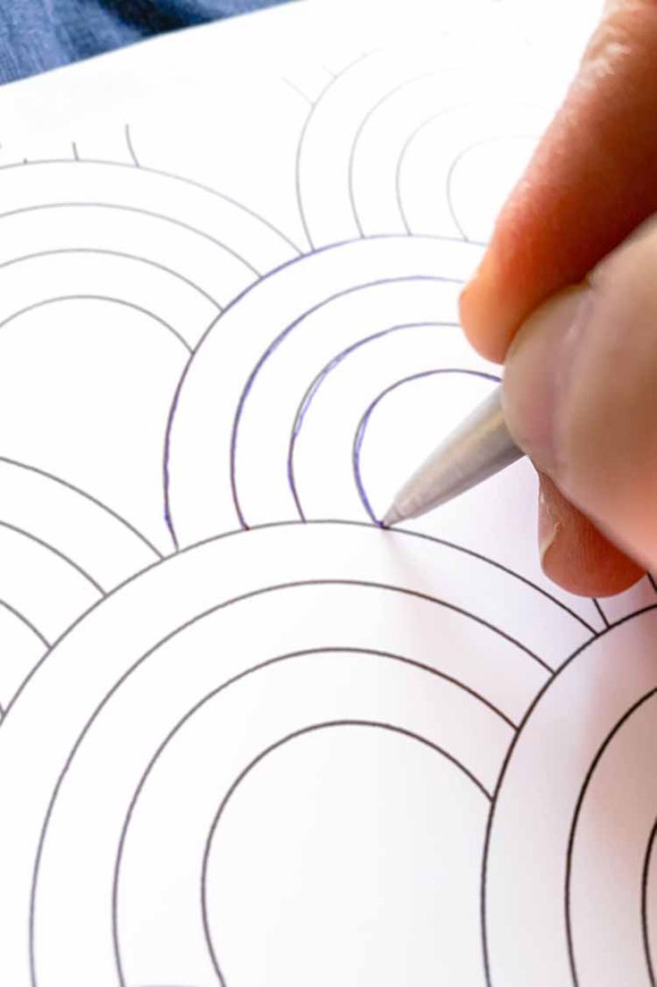 someone is drawing circles on paper with a pencil