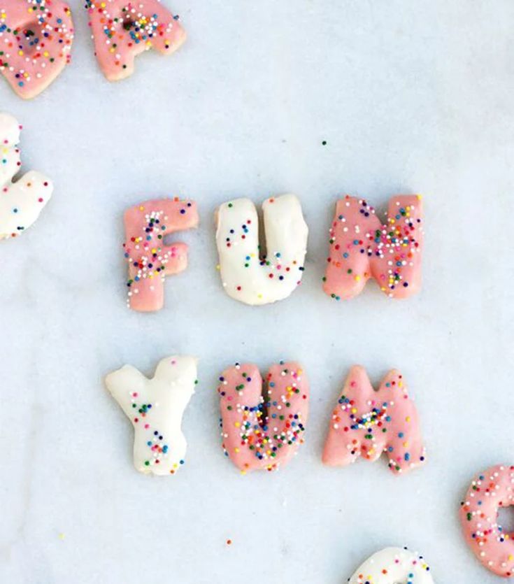 letters made out of doughnuts and sprinkles on a white surface