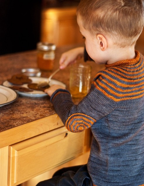 a little boy sitting at a table eating food