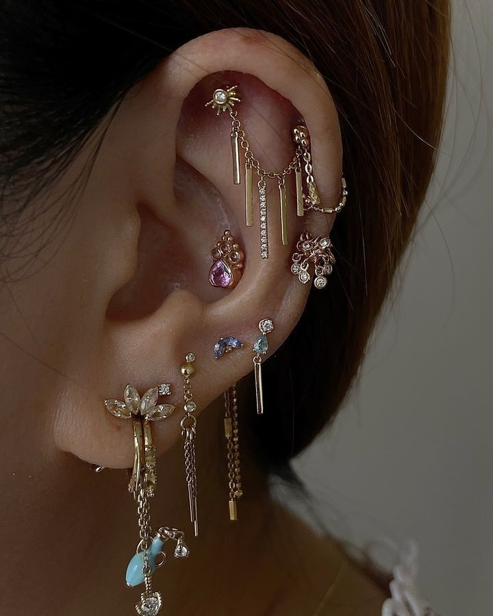 a close up of a person's ear with different types of piercings on it