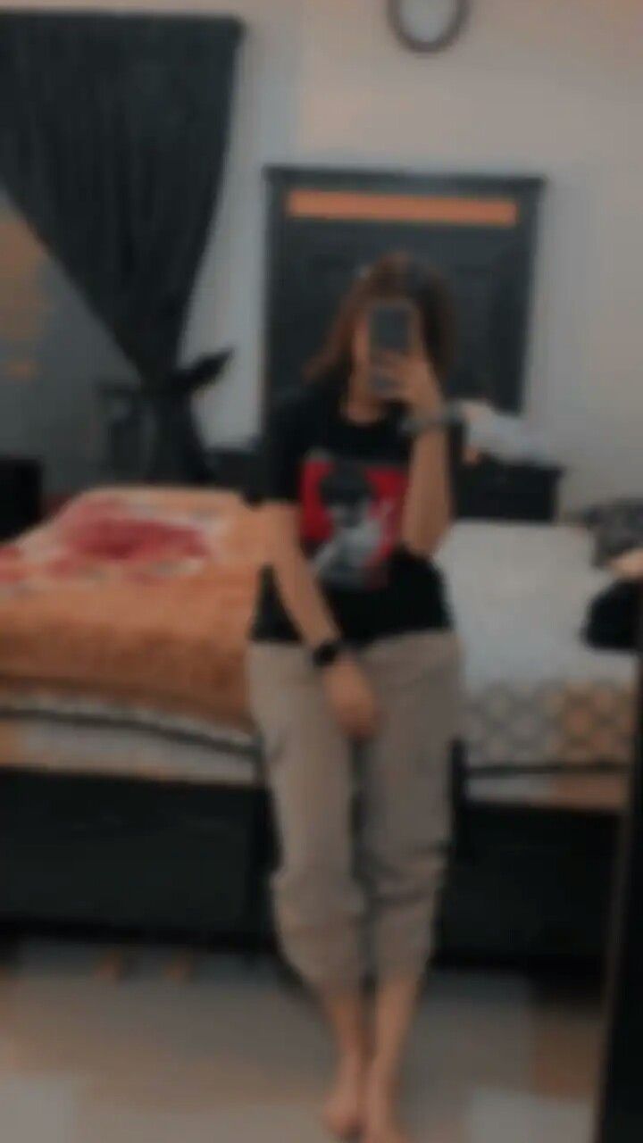 a blurry image of a woman taking a selfie in front of a bed