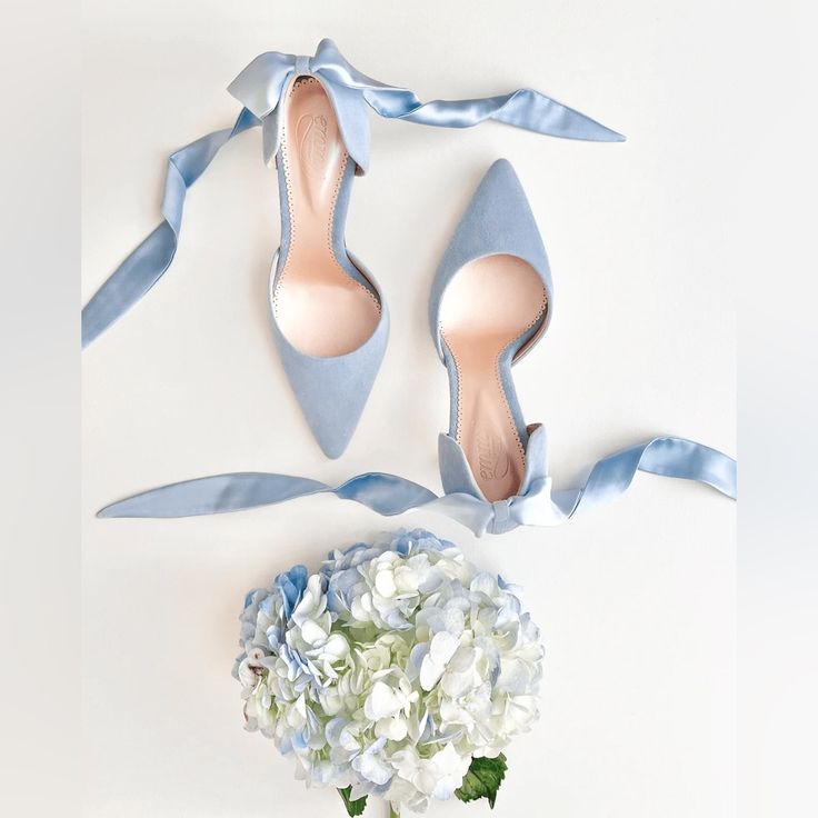 a pair of blue shoes next to a bouquet of white flowers