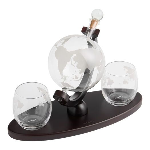 three wine glasses and a decanter on a wooden stand