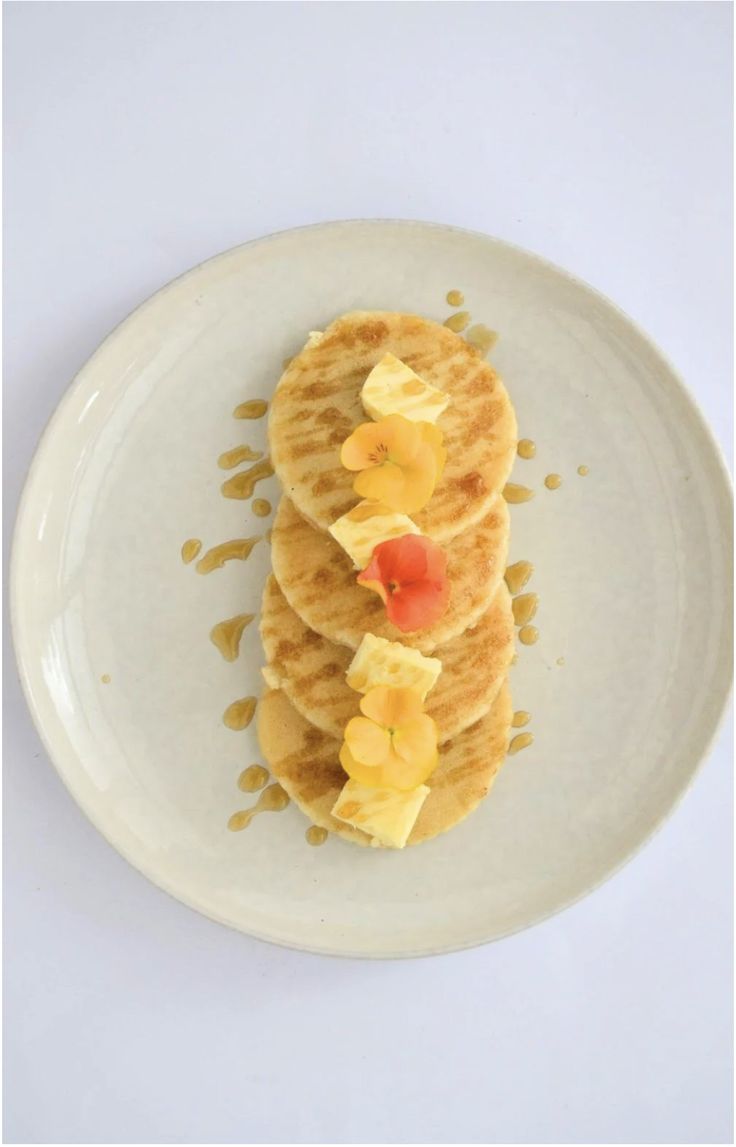 pancakes with fruit and syrup on a white plate