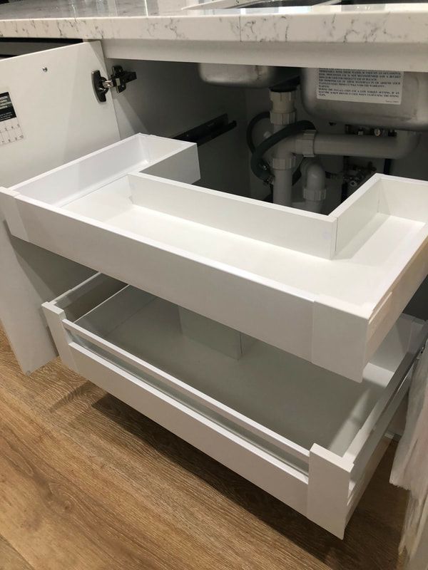 an open drawer in the middle of a kitchen