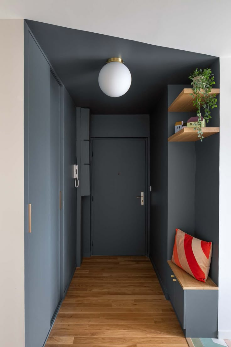 an empty hallway with blue walls and wooden flooring is seen in this image from the entryway