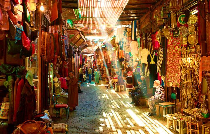 people are walking through an open market area