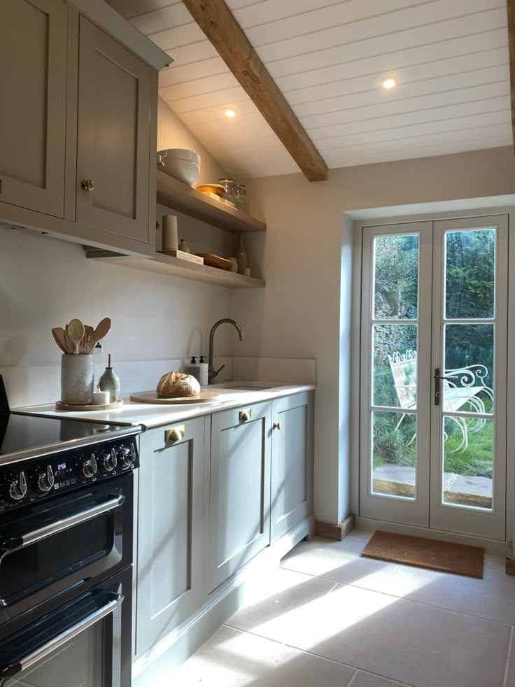 a kitchen with an oven, sink and sliding glass door leading to the outside patio