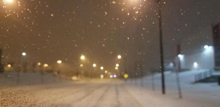 the street lights are covered in snow at night