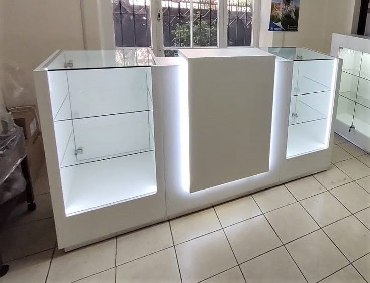 an empty kitchen with white cabinets and tile flooring