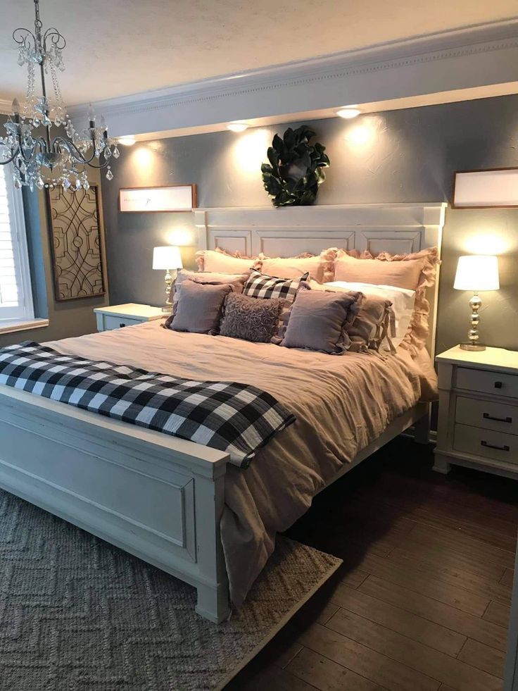 a bedroom with a bed, dresser and chandelier