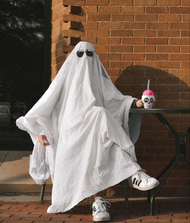 a person in a ghost costume sitting at a table