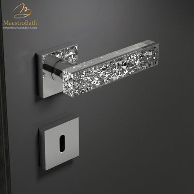 the door handle is made out of metal and has a crystal glass block on it